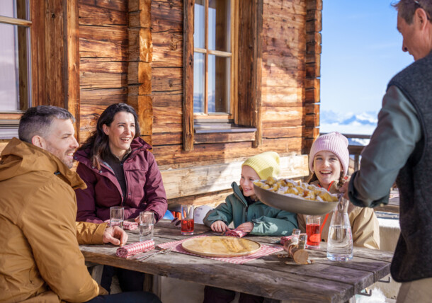    Rodina si vychutnáva cisársky trhanec na chate v lyžiarskej oblasti Ski Juwel Alpbachtal Wildschönau 